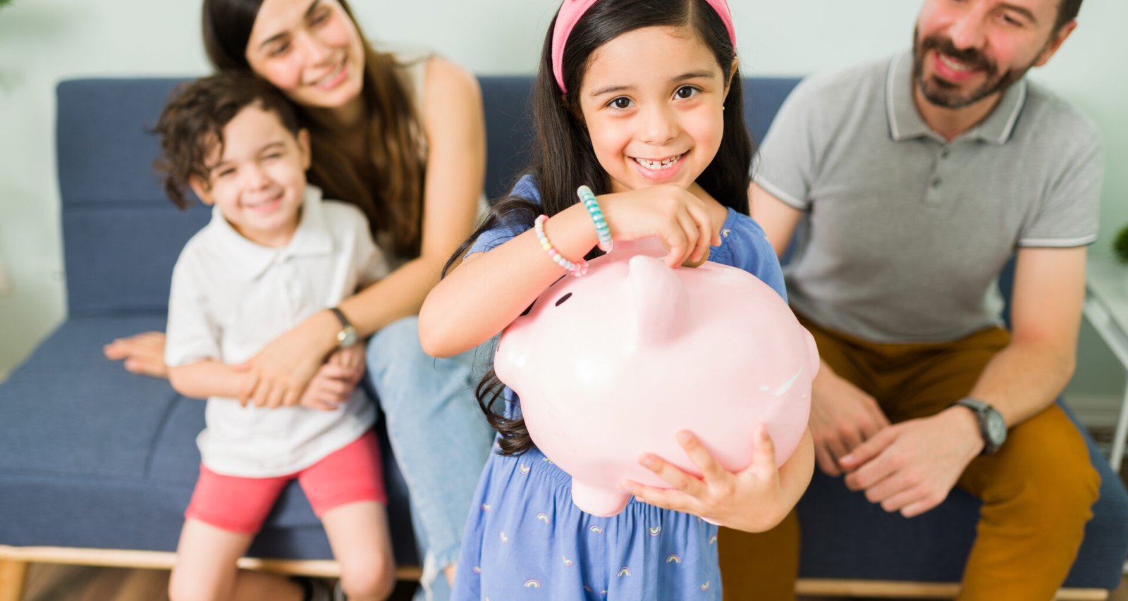 portrait cute little girl putting money pink piggy bank save new toy her her small brother